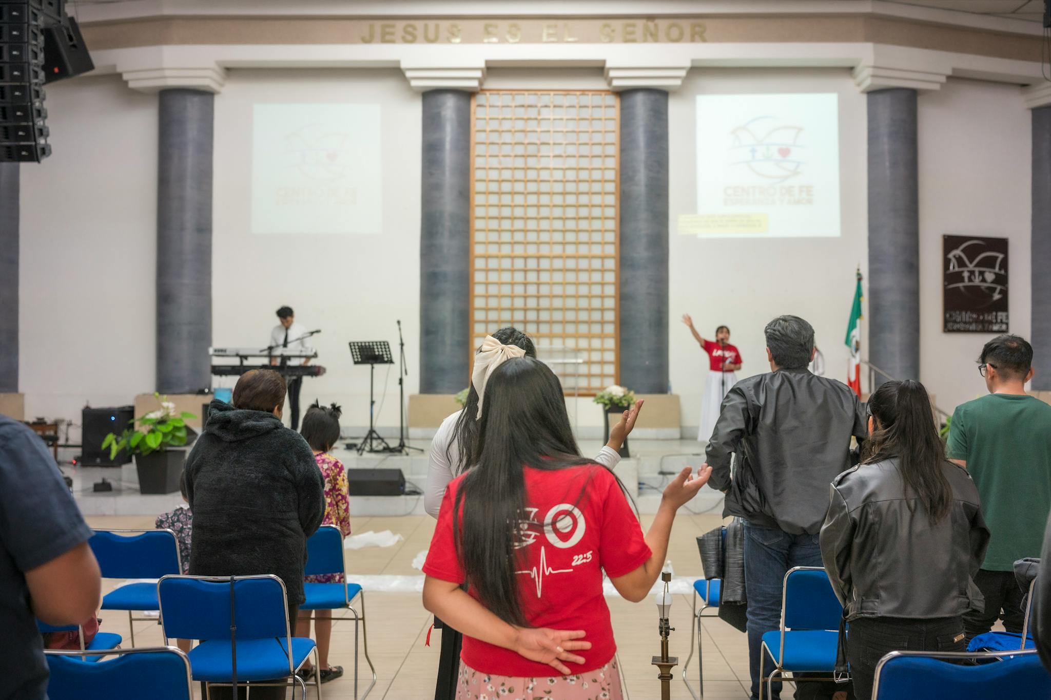 A diverse group of people praying and worshipping inside a church during a religious event.