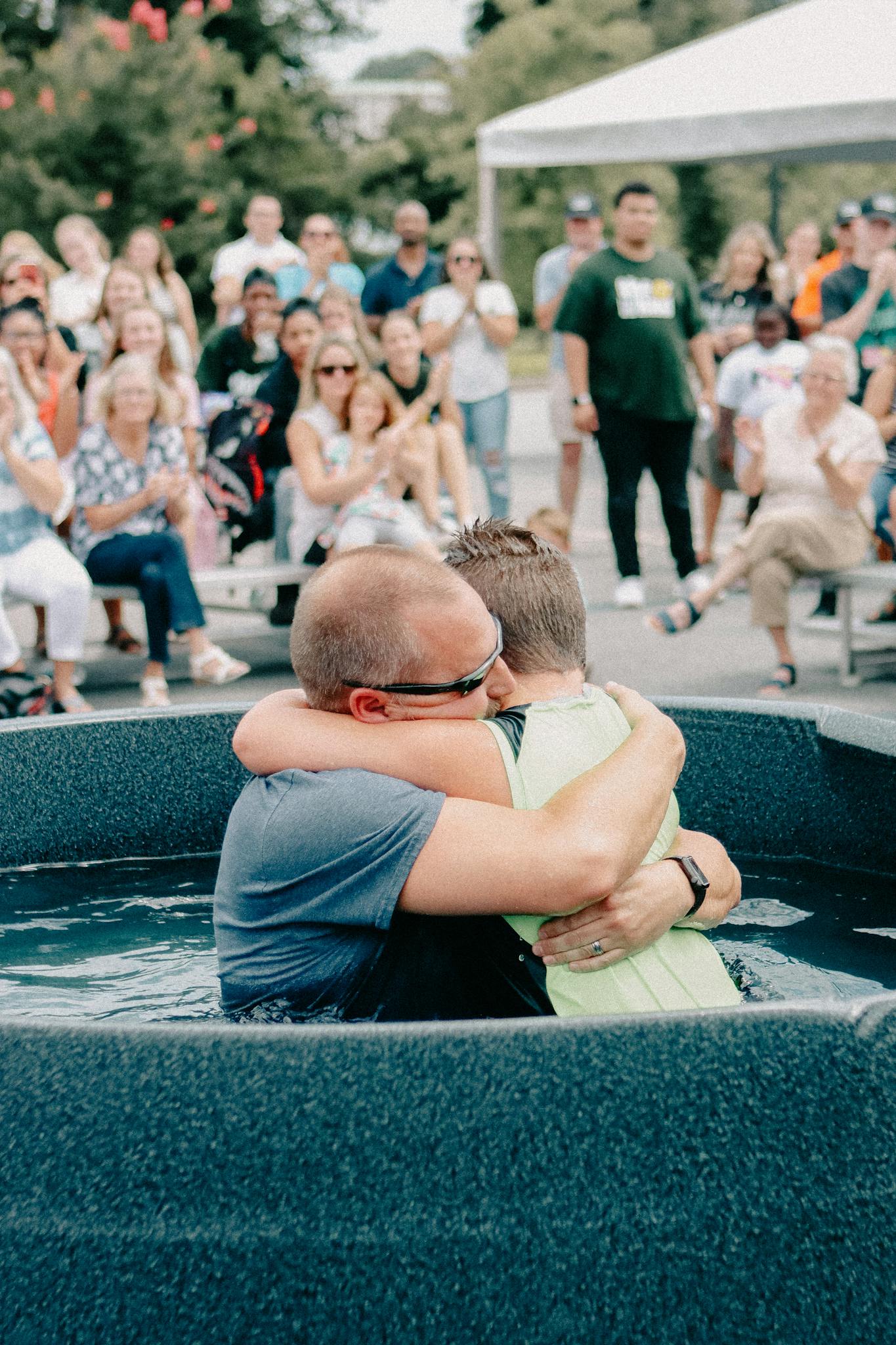 An emotional embrace during an outdoor baptism ceremony in Clemson, South Carolina.