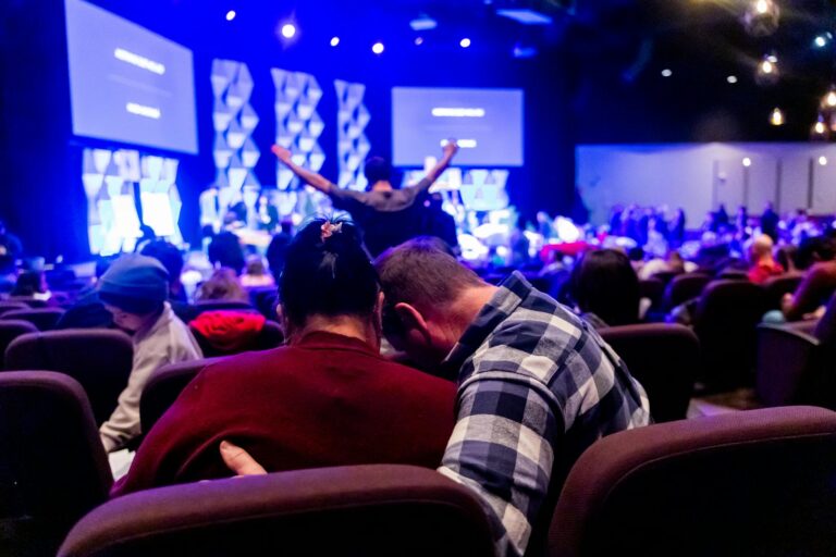 Couple shares a heartfelt moment in a warmly lit church during a service.